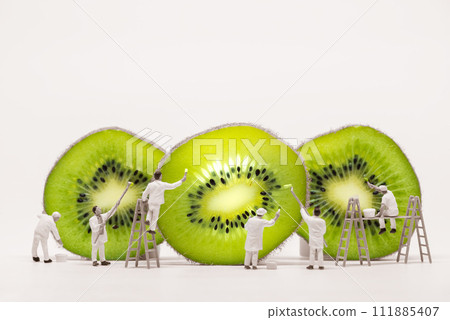 Miniature painters coloring Kiwi slices. Macro photo Miniature painters coloring Kiwi slices. Macro photo 111885407