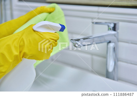 Close-up of cleaning sink with faucet in bathroom, hands in gloves with detergent 111886487