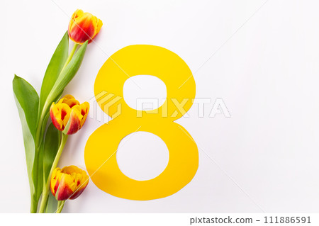 International Women's Day greeting card. 8 March concept. Tulip on yellow number eight on white background. Copy space 111886591
