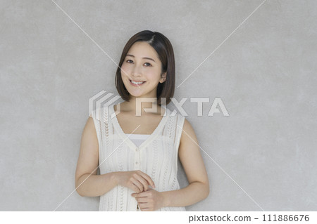 一個 20 多歲的女人微笑著看著鏡頭的美容肖像 一個 20 多歲的女人微笑著看著鏡頭的美容肖像 111886676