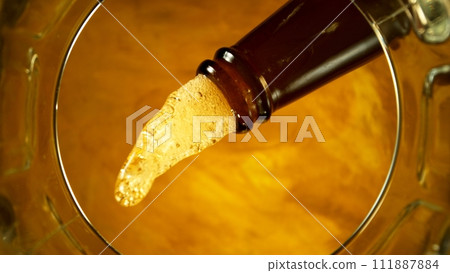 Freeze motion of pouring beer into pint. Unique angle of view from the bottom of the glass. 111887884