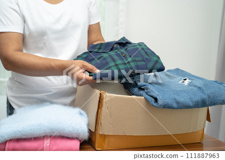 Donation box with used clothes at home to support help for poor people in the world. Donation box with used clothes at home to support help for poor people in the world. 111887963