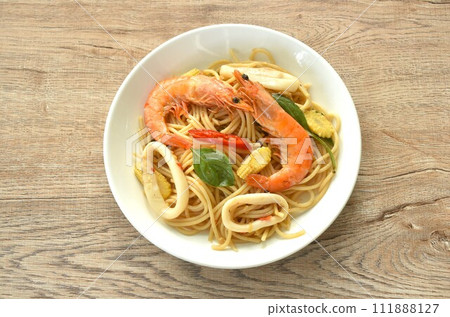 spicy stir fried spaghetti seafood couple squid shrimp with chili and basil leaf in sauce on plate spicy stir fried spaghetti seafood couple squid shrimp with chili and basil leaf in sauce on plate 111888127
