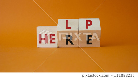 Help is here symbol. Turned wooden cubes with words Here to Help. Beautiful orange background. Business and Help is here concept. Copy space 111888235
