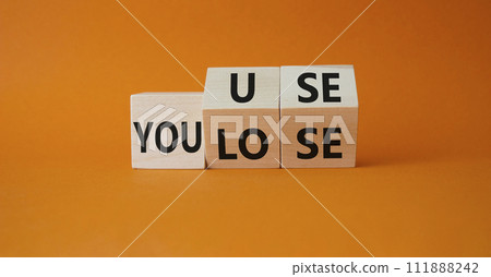 You use or lose symbol. Turned wooden cubes with words You lose or You use. Beautiful orange background. Business and You use or lose concept. Copy space You use or lose symbol. Turned wooden cubes with words You lose or You use. Beautiful orange background. Business and You use or lose concept. Copy space 111888242