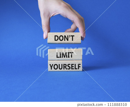 Do not limit yourself symbol. Concept words Do not limit yourself on wooden blocks. Businessman hand. Beautiful blue background. Business and Do not limit yourself concept. Copy space 111888310