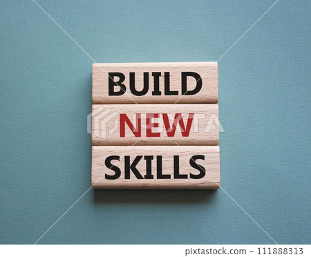 Build New skills symbol. Concept word Build New skills on wooden blocks. Beautiful grey green background. Business and Build New skills concept. Copy space 111888313