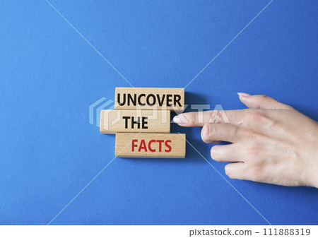 Uncover the Facts symbol. Concept word Uncover the Facts on wooden blocks. Businessman hand. Beautiful blue background. Business and Uncover the Facts concept. Copy space 111888319