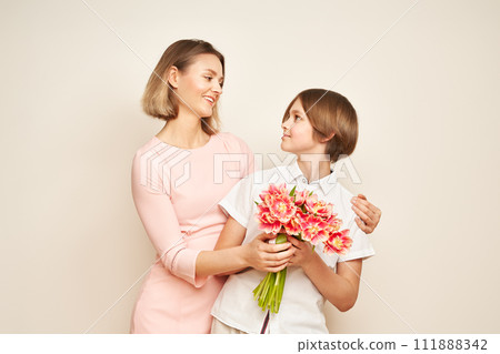 Boy gives his mother flowers Boy gives his mother flowers 111888342