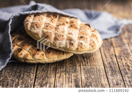 Arabic flat pita bread on wooden table. 111889192