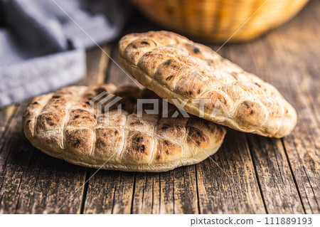 Arabic flat pita bread on wooden table. 111889193