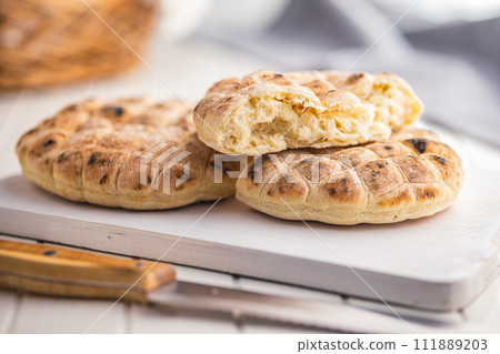 Arabic flat pita bread on white table. Arabic flat pita bread on white table. 111889203