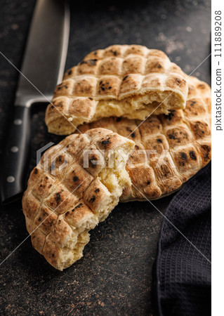Arabic flat pita bread on black table. Arabic flat pita bread on black table. 111889208