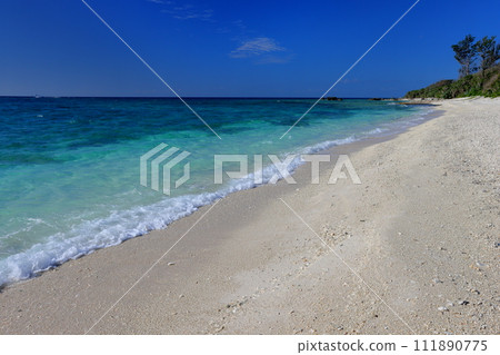 Sesoko, Motobu-cho, Kunigami-gun, Okinawa Prefecture: Minna blue sea and waves crashing against the sandy beach of Konan Beach on Minna Island, a small remote island 111890775