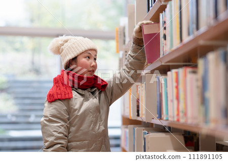 A girl choosing a book 111891105