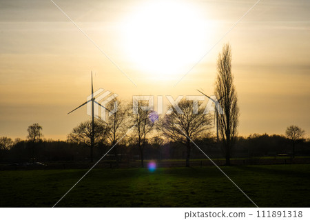 Sunset Silhouettes with Wind Turbines on the Horizon 111891318