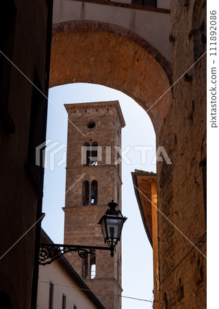 Old Romanesque bell tower of a church in downtown Volterra Old Romanesque bell tower of a church in downtown Volterra 111892086