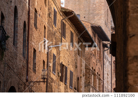 Facade of typical medieval residential houses in downtown San Gimignano 111892100
