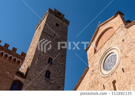 Main square Piazza del Duomo in San Gimignano with its famous palace towers, the big tower of Palazzo Comunale and the cathedral in the center 111892135