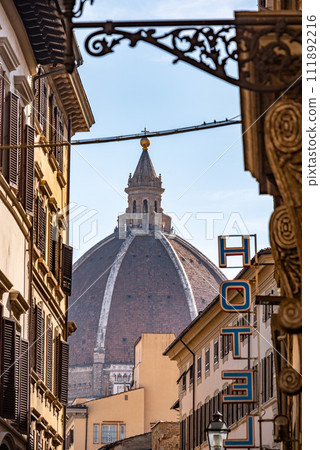Cupola of the cathedral Santa Maria del Fiore in Florence, seen from a street far away 111892216