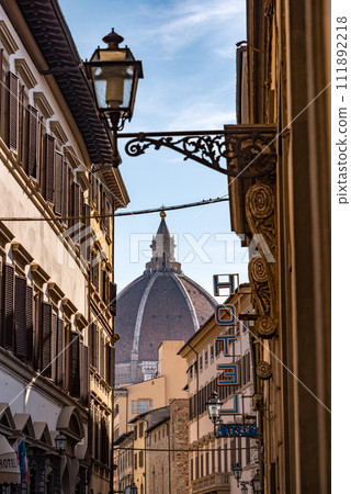 Cupola of the cathedral Santa Maria del Fiore in Florence, seen from a street far away Cupola of the cathedral Santa Maria del Fiore in Florence, seen from a street far away 111892218
