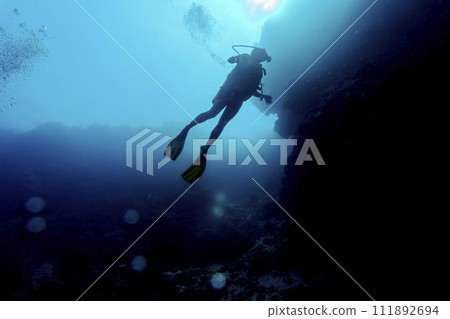 Silhouette of scuba divers underwater. Diving concept. Beautiful underwater world. Underwater photography. Silhouette of scuba divers underwater. Diving concept. Beautiful underwater world. Underwater photography. 111892694