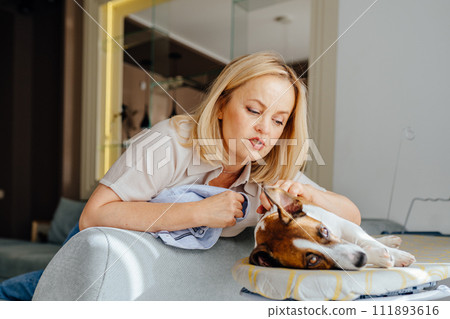 Friend of family concept. Portrait of mature blond woman with her adorable wire haired Jack Russel terrier puppy at home. 111893616