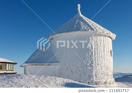 Winter morning , wooden Roman catholic chapel and disc shaped meteorological observatory in snezka, mountain on the border between Czech Republic and Poland. Winter morning , wooden Roman catholic chapel and disc shaped meteorological observatory in snezka, mountain on the border between Czech Republic and Poland. 111893717