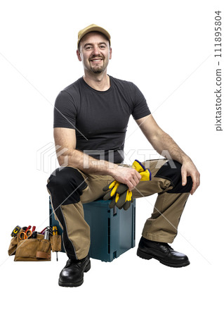 Smiling handyman seated with tools Smiling handyman seated with tools 111895804
