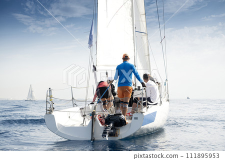 Crew on sailboat during regatta 111895953