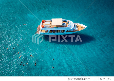 Cruise boat and swimming tourists at blue lagoon. Latchi, Paphos District, Cyprus 111895959
