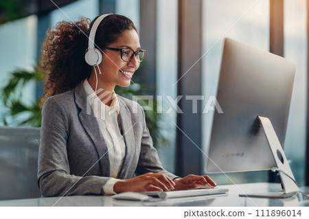 A woman headed to a computer with a headset attached 111896014