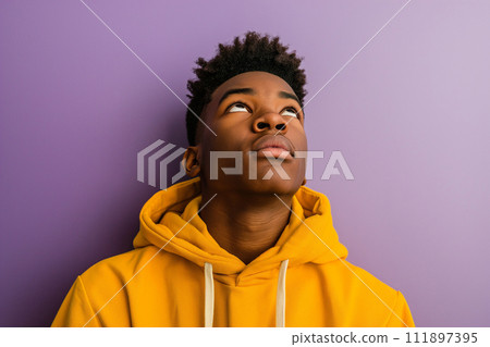 African American serious teenage boy wearing hoodie on purple background 111897395