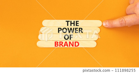The power of brand symbol. Concept words The power of brand on wooden stick. Beautiful orange table orange background. Businessman hand. Business the power of brand concept. Copy space. 111898255