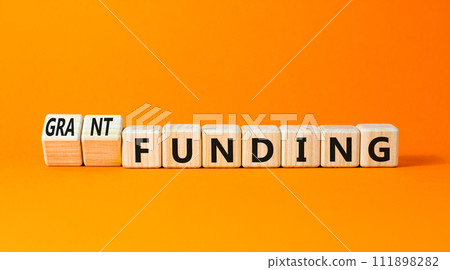 Grant funding symbol. Concept words Grant funding on beautiful wooden blocks. Beautiful orange table orange background. Business and grant funding concept. Copy space. 111898282