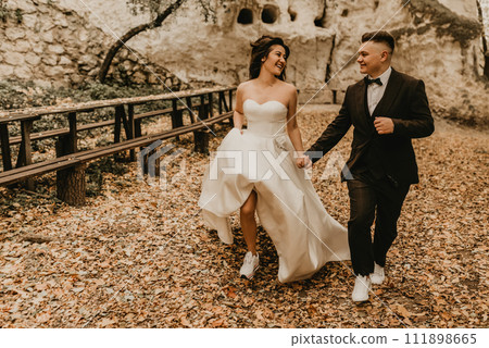 wedding couple in love man and woman run happy in autumn forest background of stone rocks wedding couple in love man and woman run happy in autumn forest background of stone rocks 111898665
