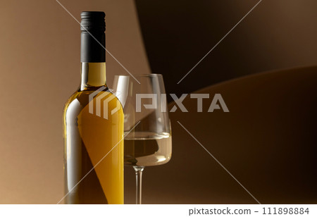 Bottle and glass of white wine. 111898884