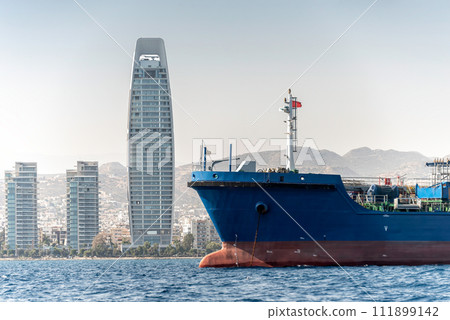 Close-up of cargo ship and Limassol cityscape. Cyprus Close-up of cargo ship and Limassol cityscape. Cyprus 111899142