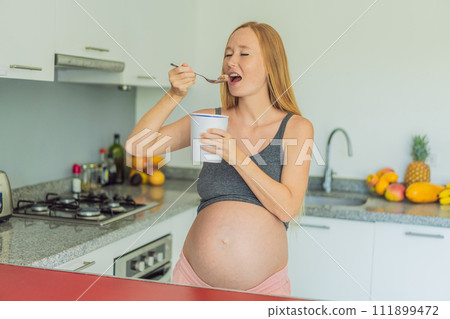 Happy pregnant young woman eating ice cream Happy pregnant young woman eating ice cream 111899472