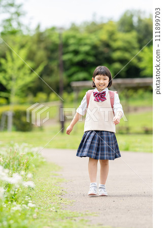 Smiling girl carrying a parcel 111899703