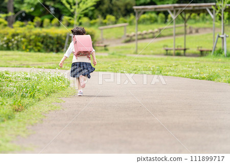Elementary school girl running to school Elementary school girl running to school 111899717