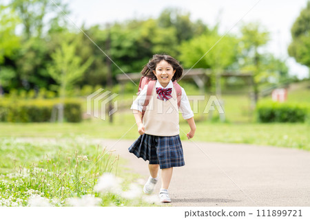 Elementary school girl running to school Elementary school girl running to school 111899721