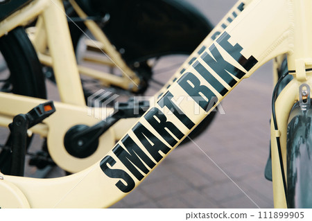 A detailed shot of a sleek bicycle parked on a sidewalk, showcasing its advanced features like a crankset, rim, and bicycle tire A detailed shot of a sleek bicycle parked on a sidewalk, showcasing its advanced features like a crankset, rim, and bicycle tire 111899905