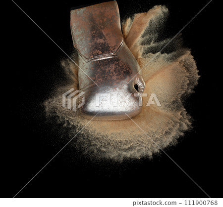 Boxing glove hit sand and explode. Gold Boxer glove impact sand splash as exercise training. Black background isolated Boxing glove hit sand and explode. Gold Boxer glove impact sand splash as exercise training. Black background isolated 111900768