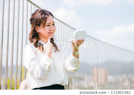 A woman/business woman who retouches her makeup during a break (lipstick, lip rouge, gloss, lips, lips) 111901481