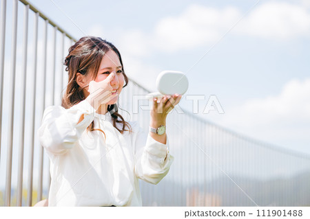 一位女士在休息時修飾妝容（鼻整形、眉間、眉毛、皺紋、鼻根、整形手術、眼睛、眼睛周圍） 111901488