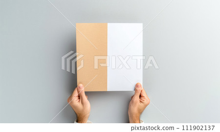 AI-generated content. hands holding a half-brown, half-white cardboard on a gray background. 111902137