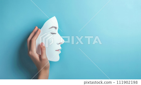 AI-generated content. A hand holding a white mask with a serene female facial feature against a solid teal background, embodying themes of identity and introspection 111902198
