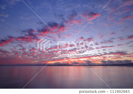 Sunrise sky from Kouri Ohashi Bridge, which connects Kouri Island and Yagaji Island in the direction of Okinawa's main island, Nakijin Village, Kunigami District, Okinawa Prefecture Sunrise sky from Kouri Ohashi Bridge, which connects Kouri Island and Yagaji Island in the direction of Okinawa's main island, Nakijin Village, Kunigami District, Okinawa Prefecture 111902665