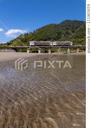 退潮時的沙紋和藍天，JR九州日南線觀光列車海幸山幸倒映在潮汐站 111903059